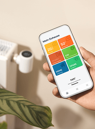 Die tado° App mit einem Heizkörperthermostat im Hintergrund